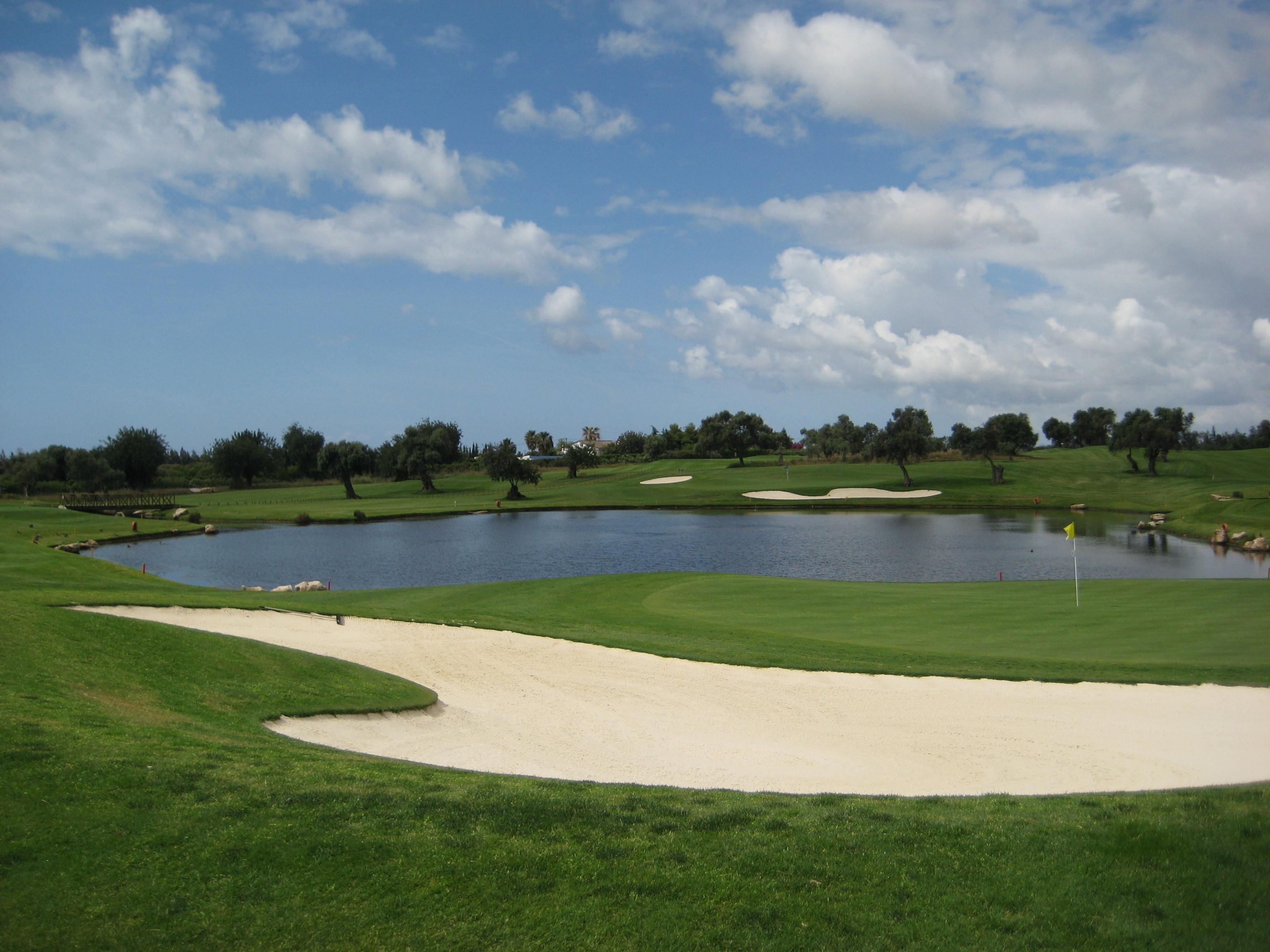 gold course under white and blue cloudy sky