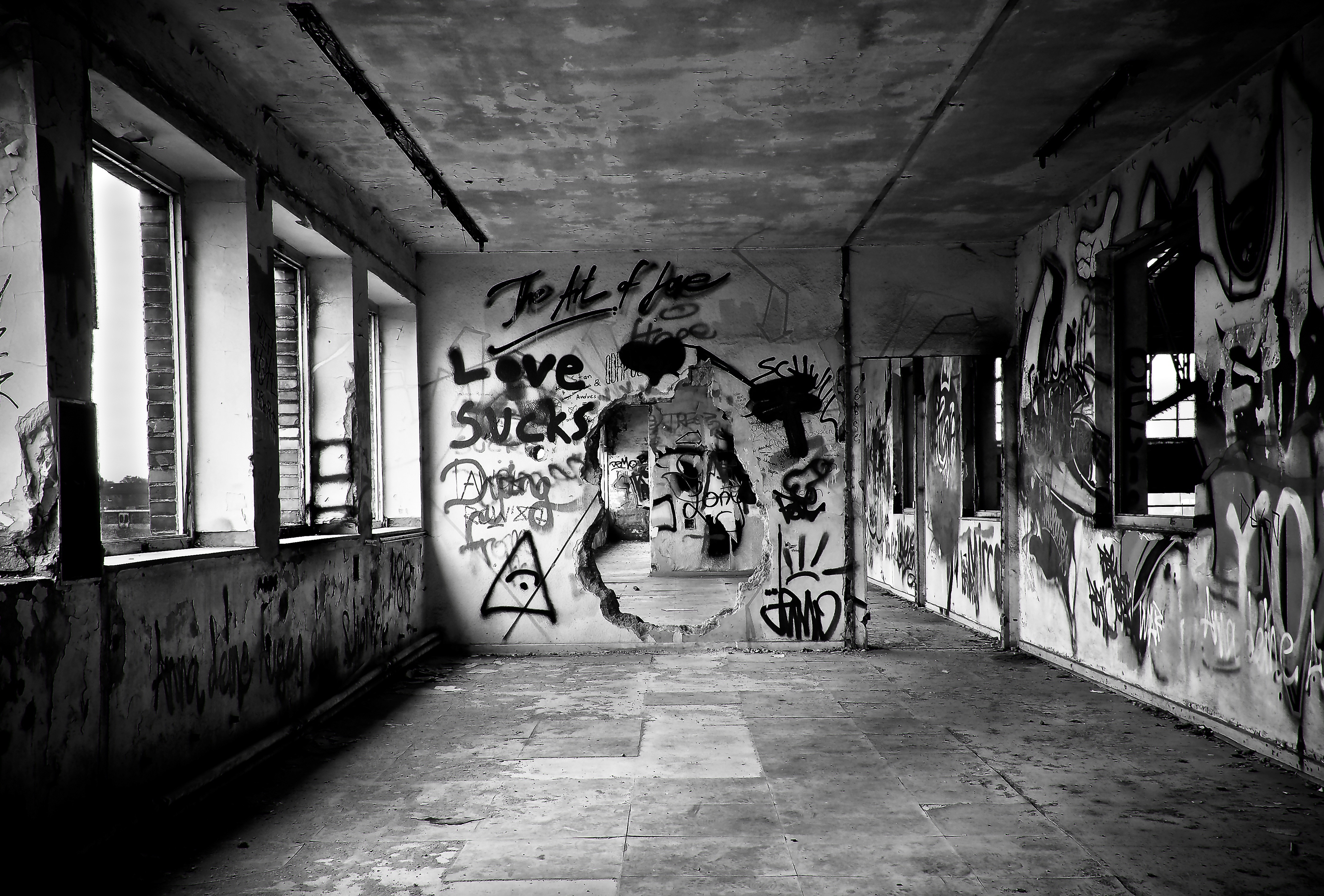 grayscale photo of concrete abandoned building with wall graffiti