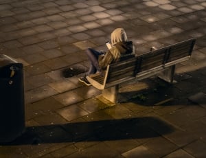 person sitting in gray bench beside post box thumbnail