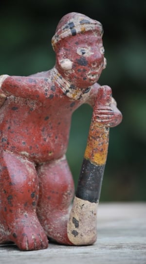 red tribal man bending figurine thumbnail