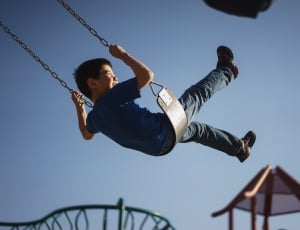 boy in blue t-shirt and blue denim pants outfit on swing thumbnail