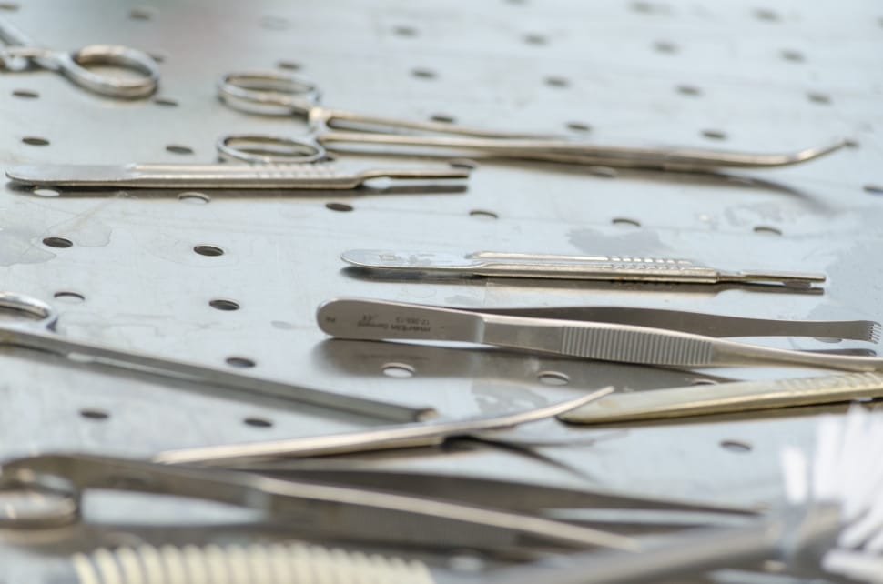 assorted stainless steel medical tools on tray preview