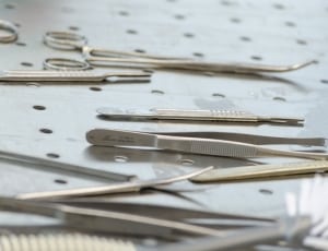 assorted stainless steel medical tools on tray thumbnail