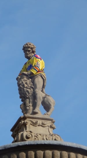 man riding lion statue during daytime thumbnail