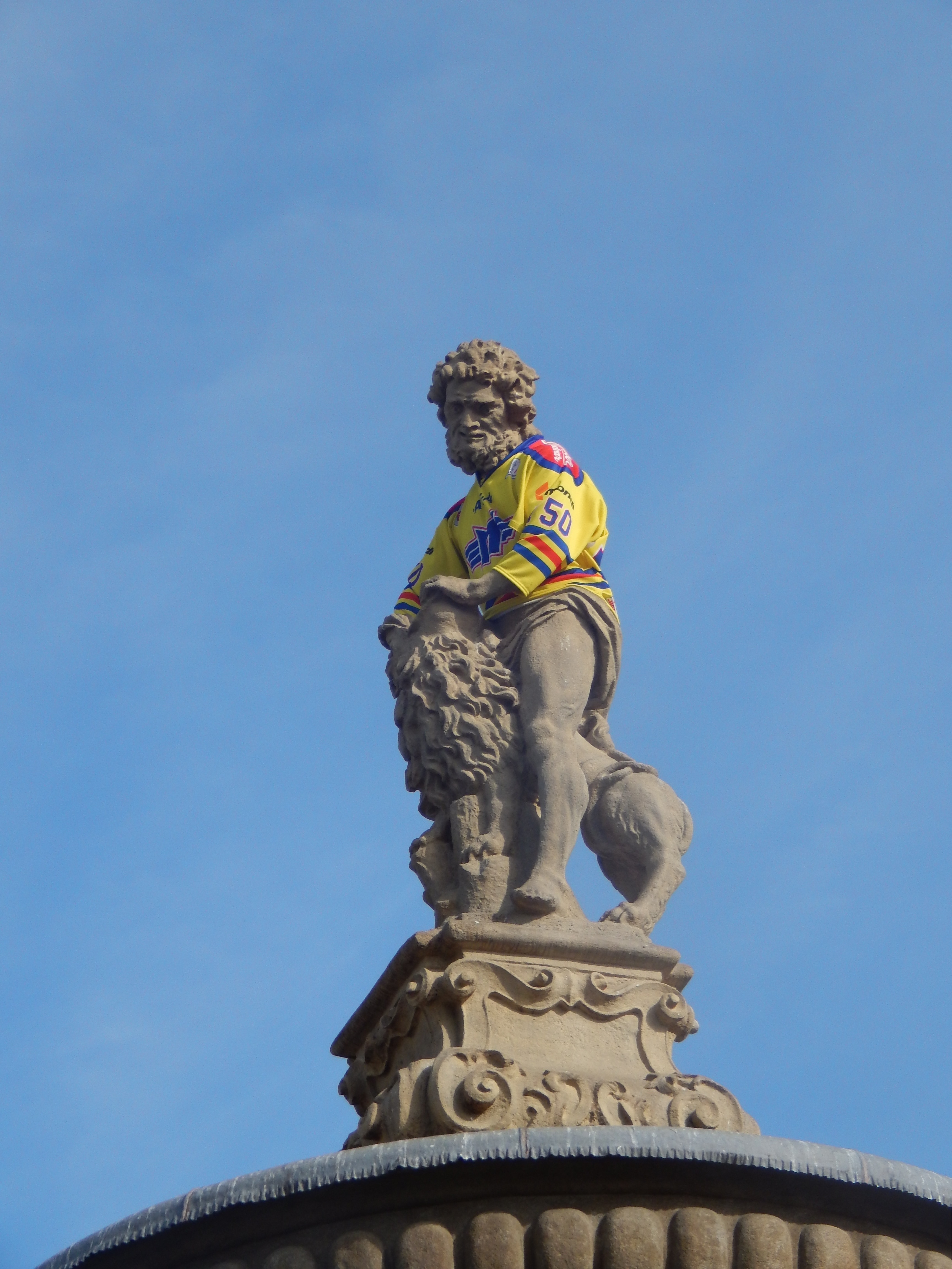 man riding lion statue during daytime