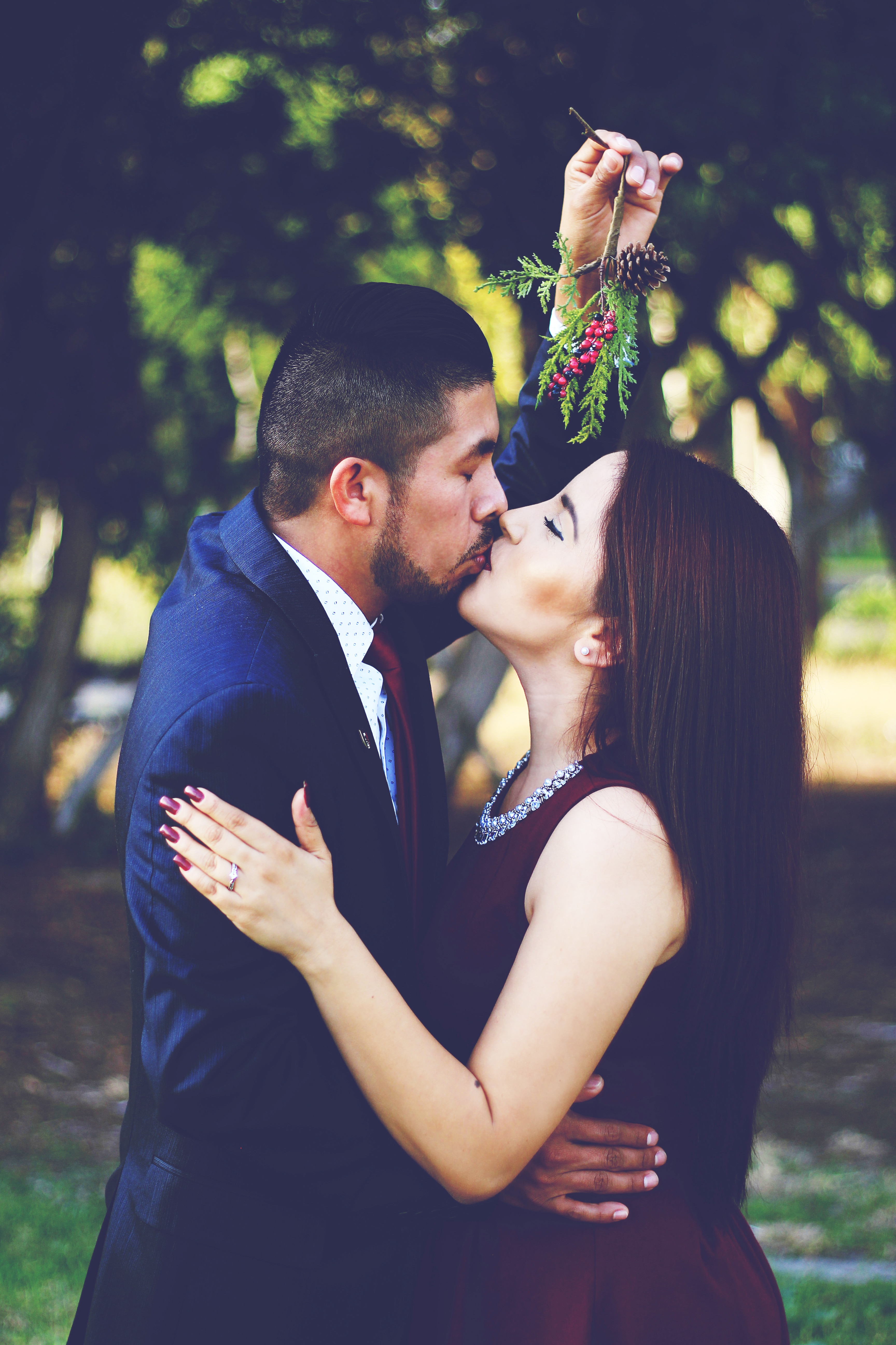 man holding mistletoe kissing woman