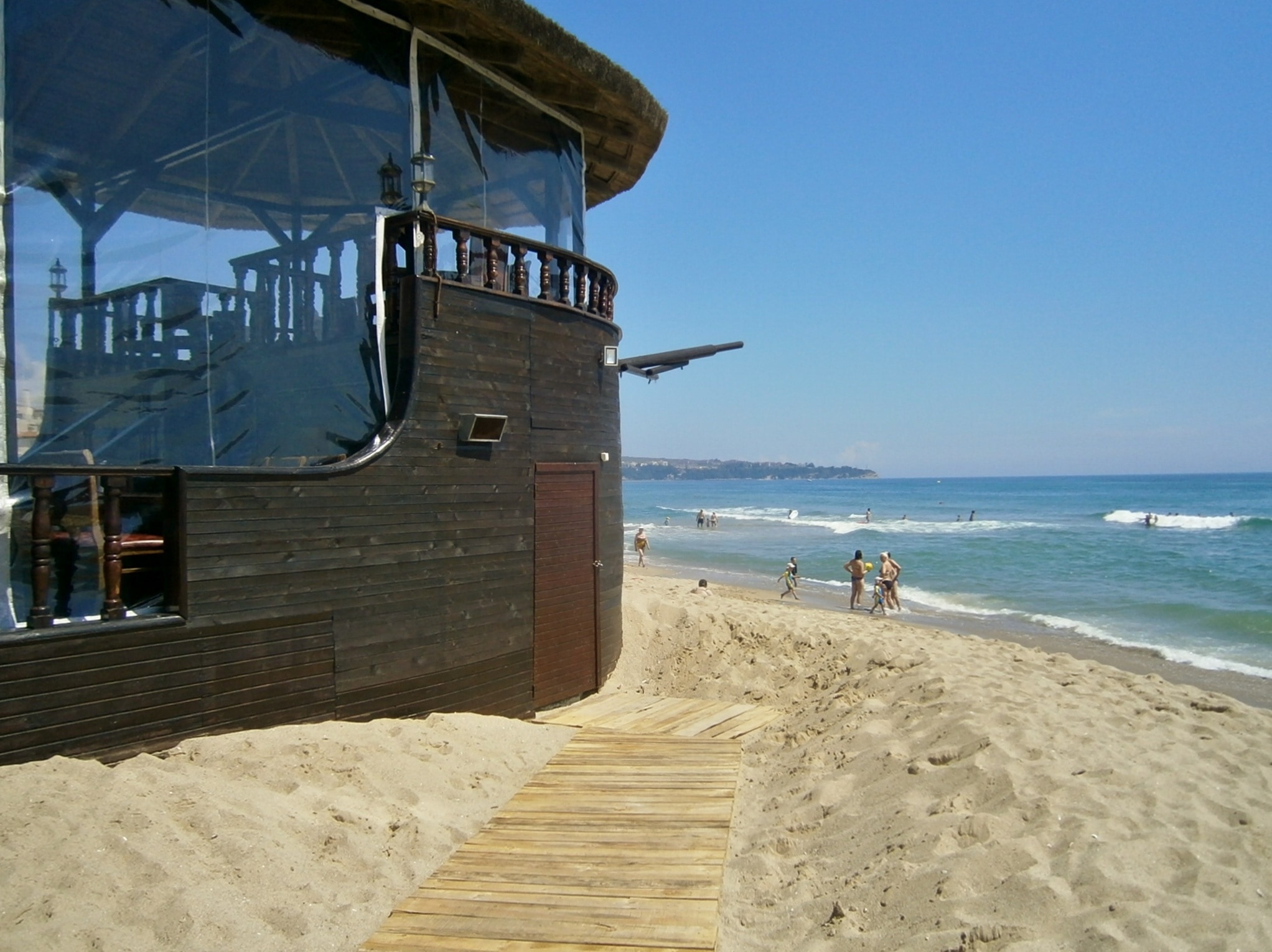 brown wooden restaurant near body of water during daytime