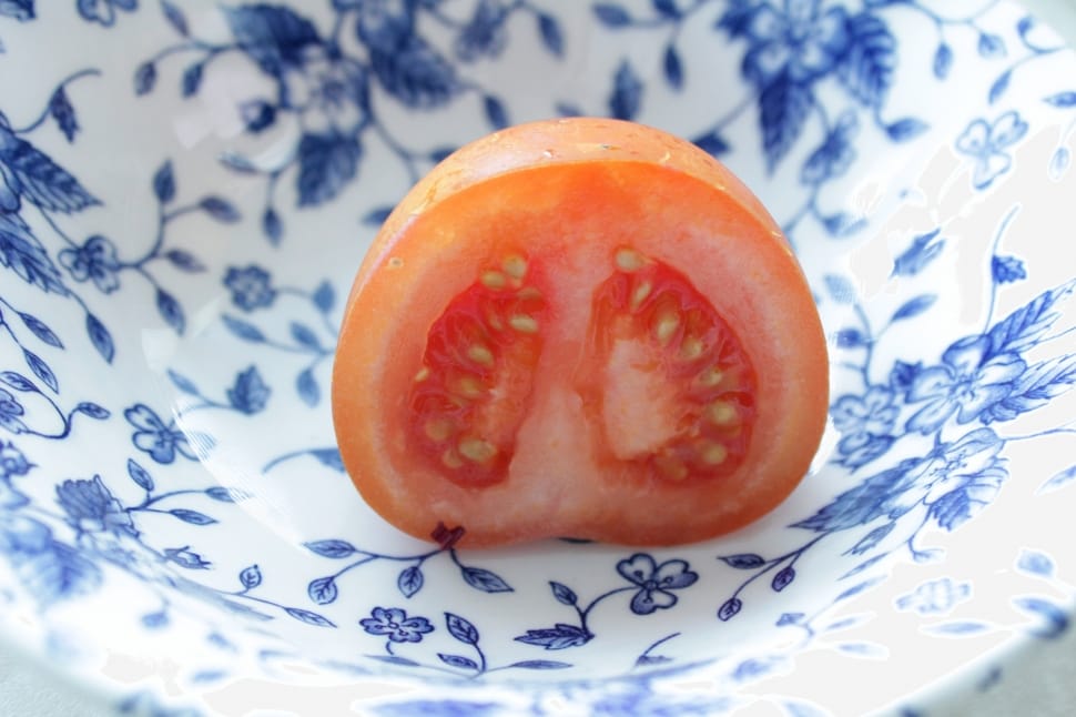 slice tomato on blue and white floral ceramic bowl preview