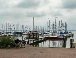 boats near dock near bike during daytime thumbnail
