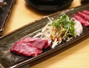 sliced red meat and green leaves thumbnail