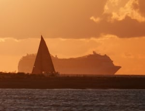silhouette photo of cruise ship and sail boat thumbnail