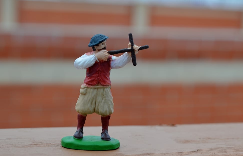 selective focus photo of man holding cross figurine preview