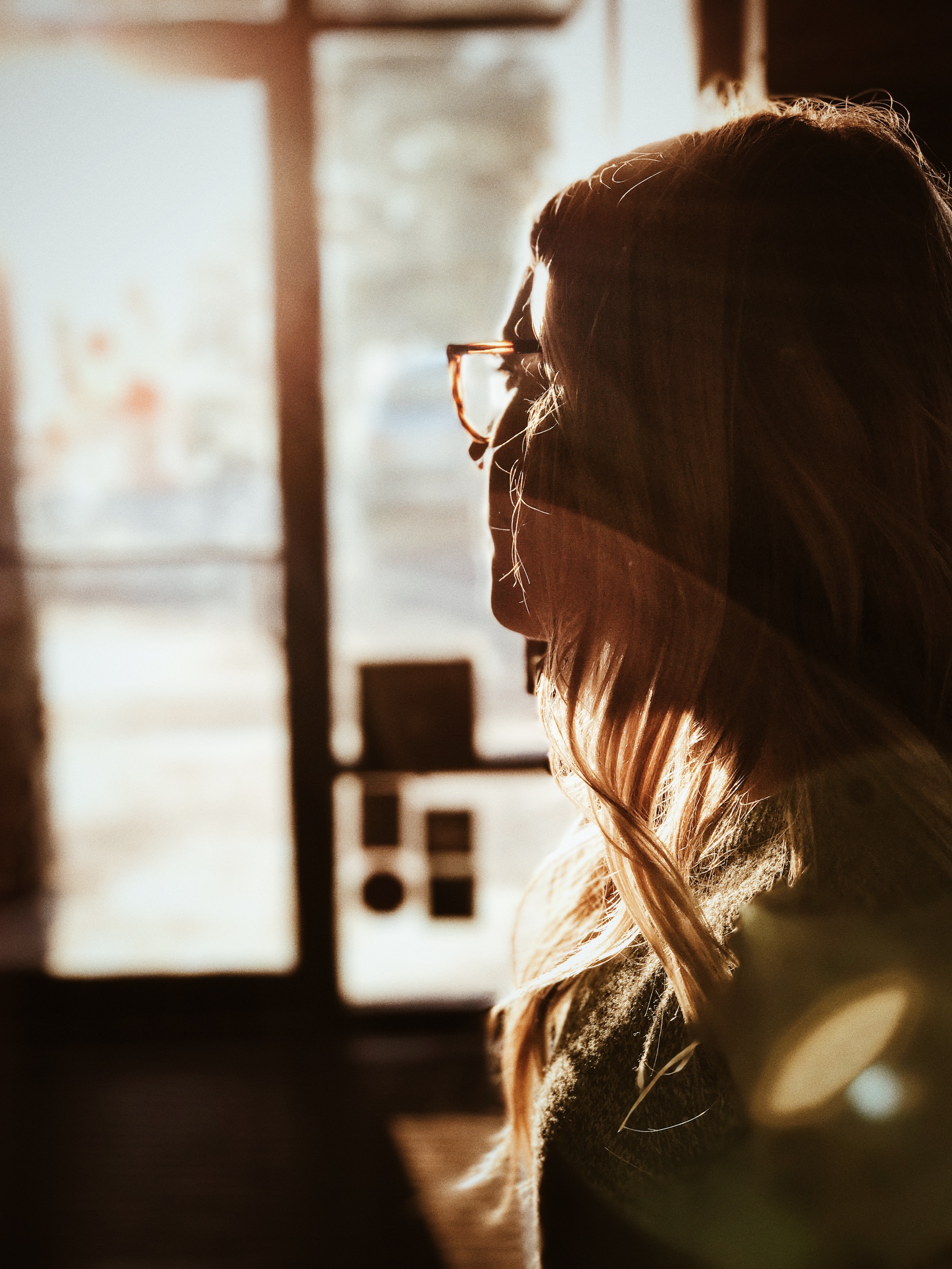 woman in gray knit shirt near clear glass wall