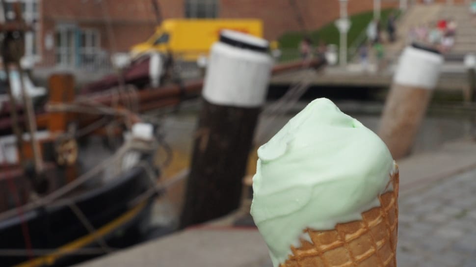 selective focus photograph of vanilla ice cream near black fishing boat preview