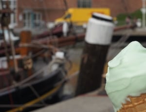 selective focus photograph of vanilla ice cream near black fishing boat thumbnail
