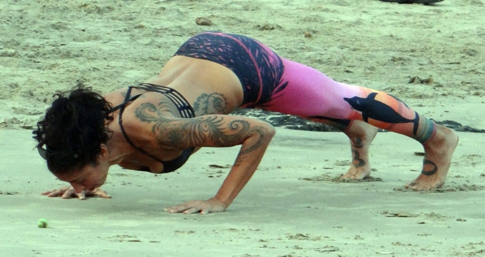 woman doing push ups on the sand preview