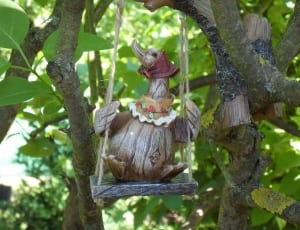 brown wooden goose sitting on swing ornament thumbnail