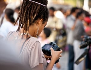 woman holding dslr camera during daytime thumbnail
