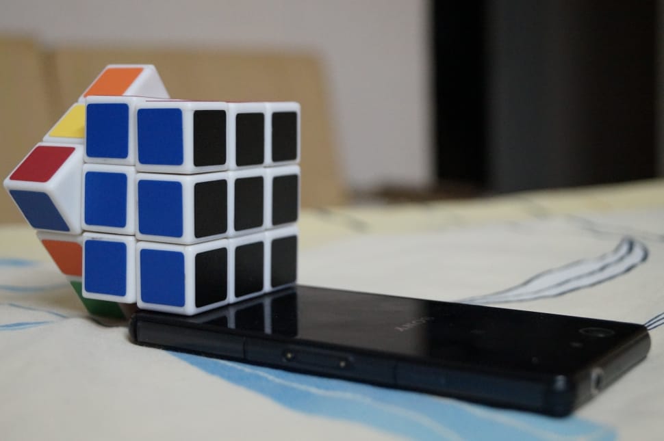 black smartphone and rubik's cube preview