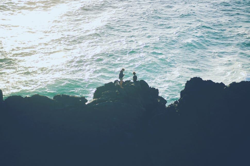 two person on rock cliff beside body of water during daytime ] preview