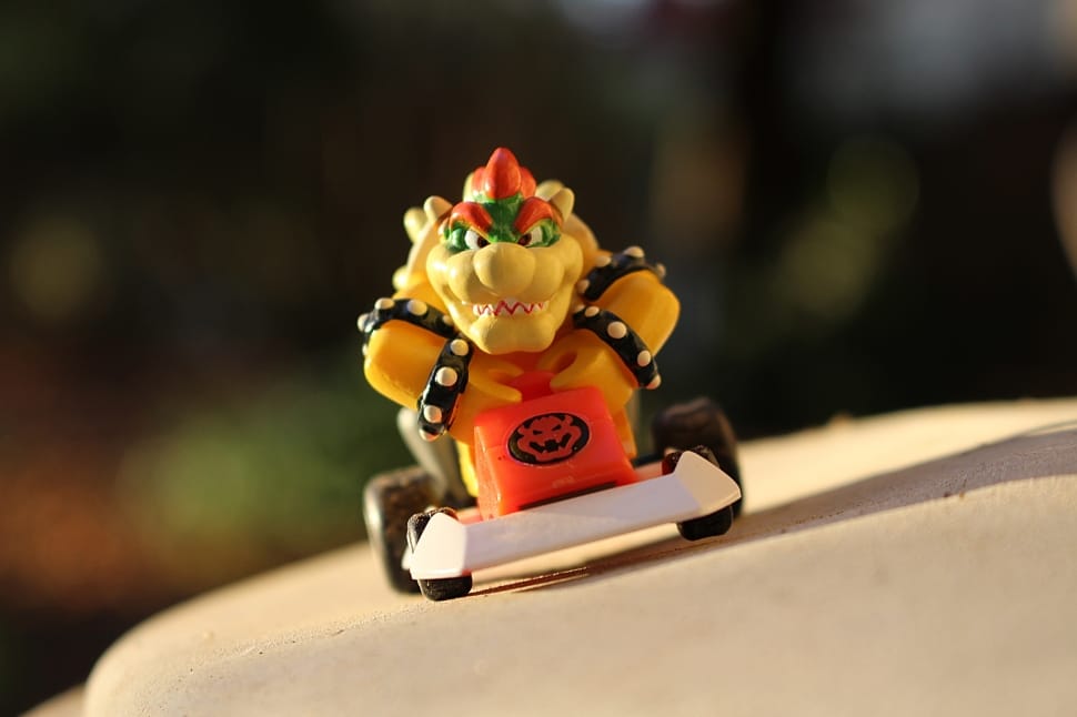 yellow orange and green dragon riding on go kart toy preview