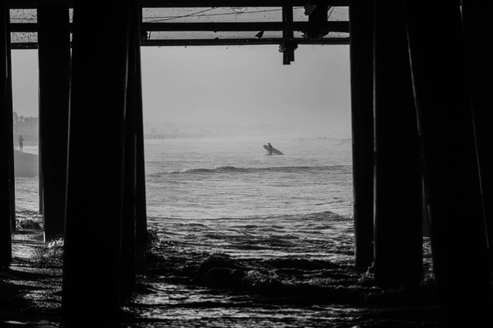 view from under the dock showing surfer in grayscale photography preview