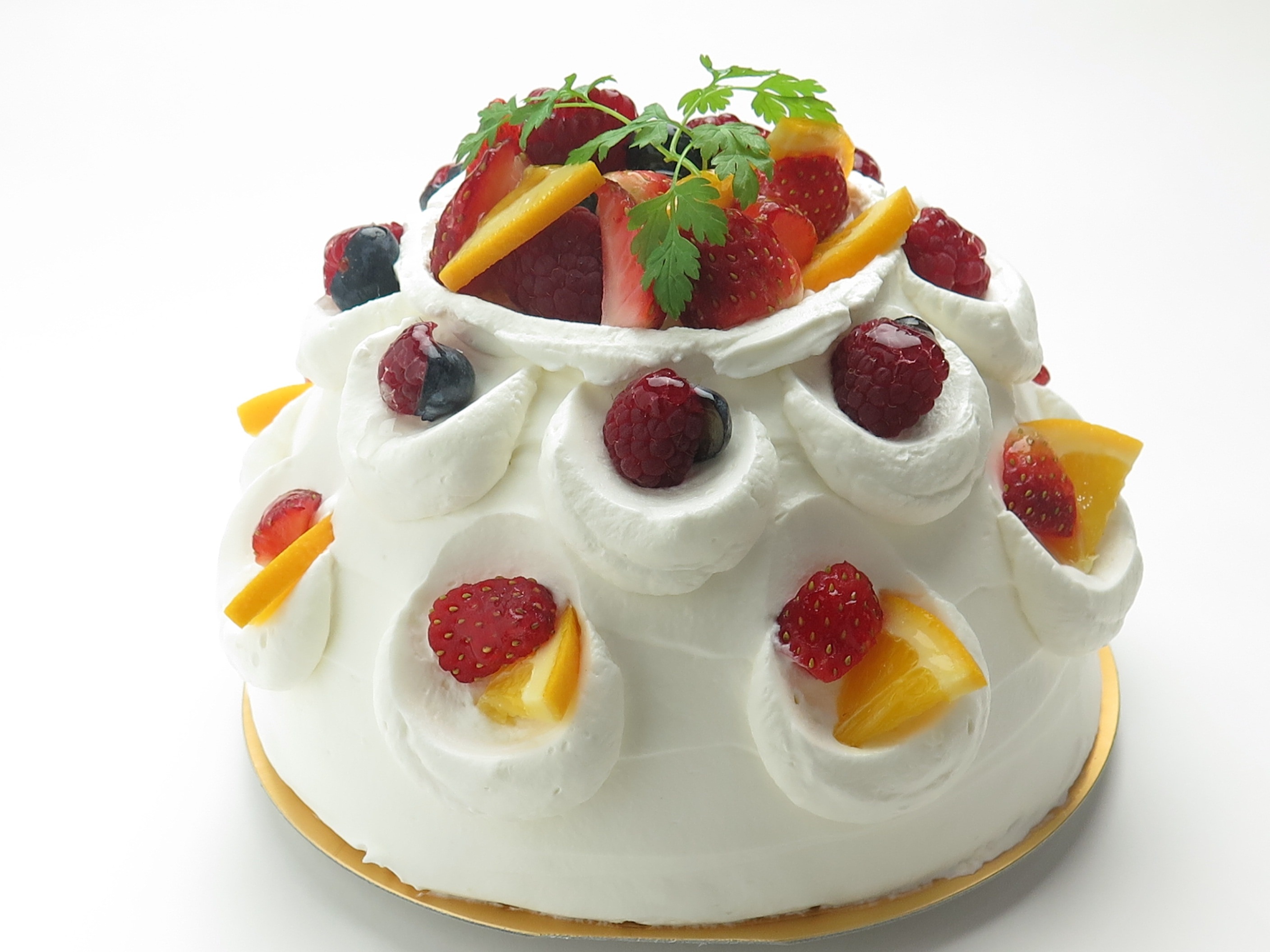 whit frosted cake with strawberry and orange toppings