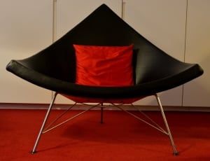 black leather chair with red throw pillow thumbnail