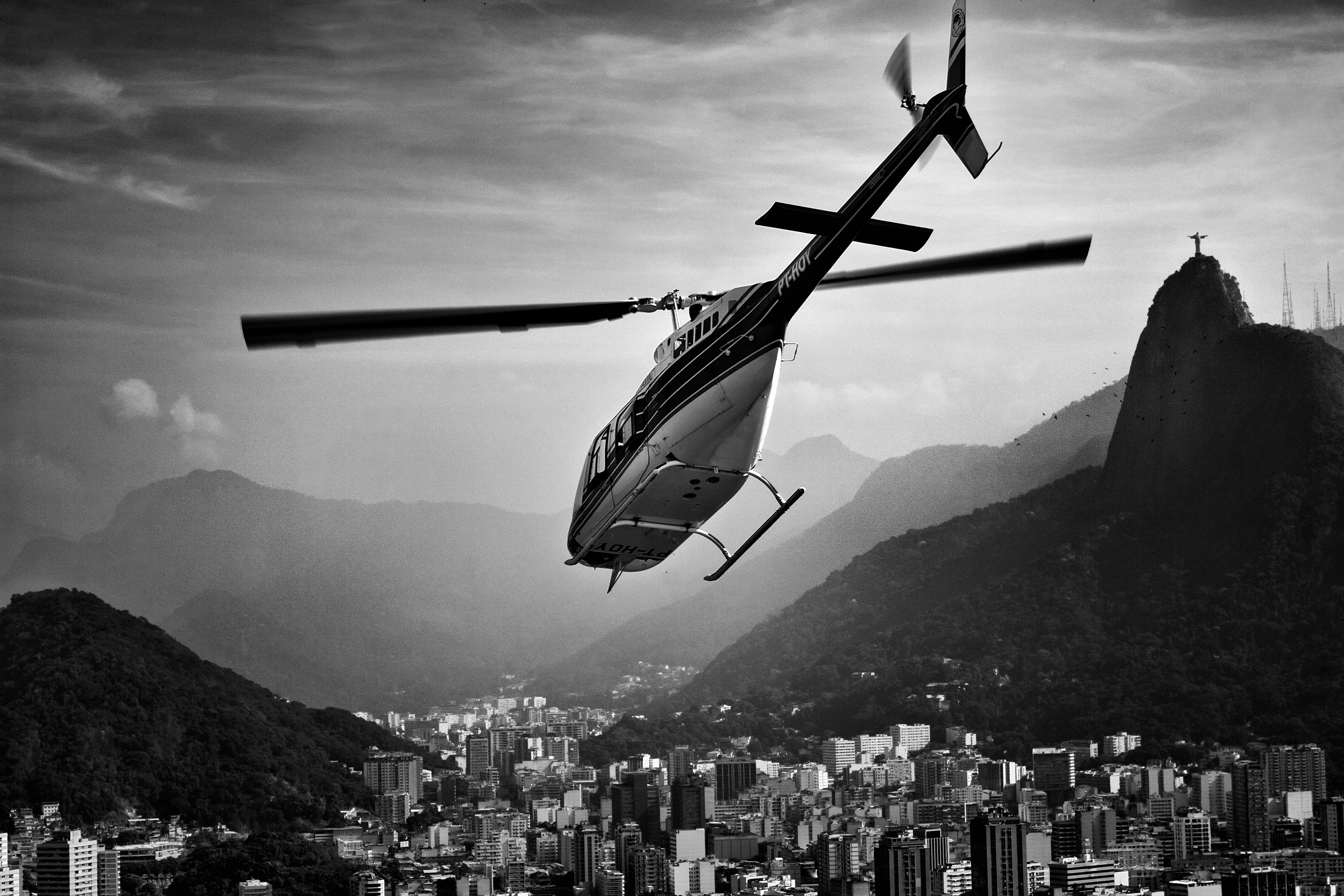 grayscale photo of flying helicopter