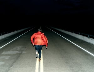 woman in red jacket running in center road thumbnail