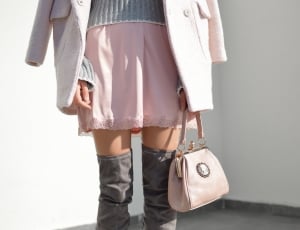 person wearing a pink mini skirt while holding a pink handbag thumbnail