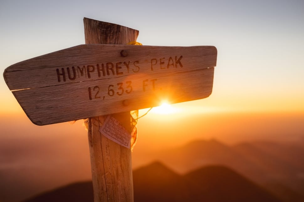 close-up photo of humphreys peak 12,633 feet wooden sign during golden hour preview
