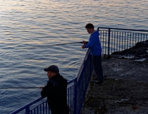 two man in hooded jacket fishing during daytime thumbnail