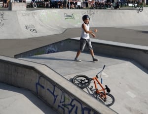 man wearing helmet standing on the middle of ramp his bmx bike on the ground thumbnail