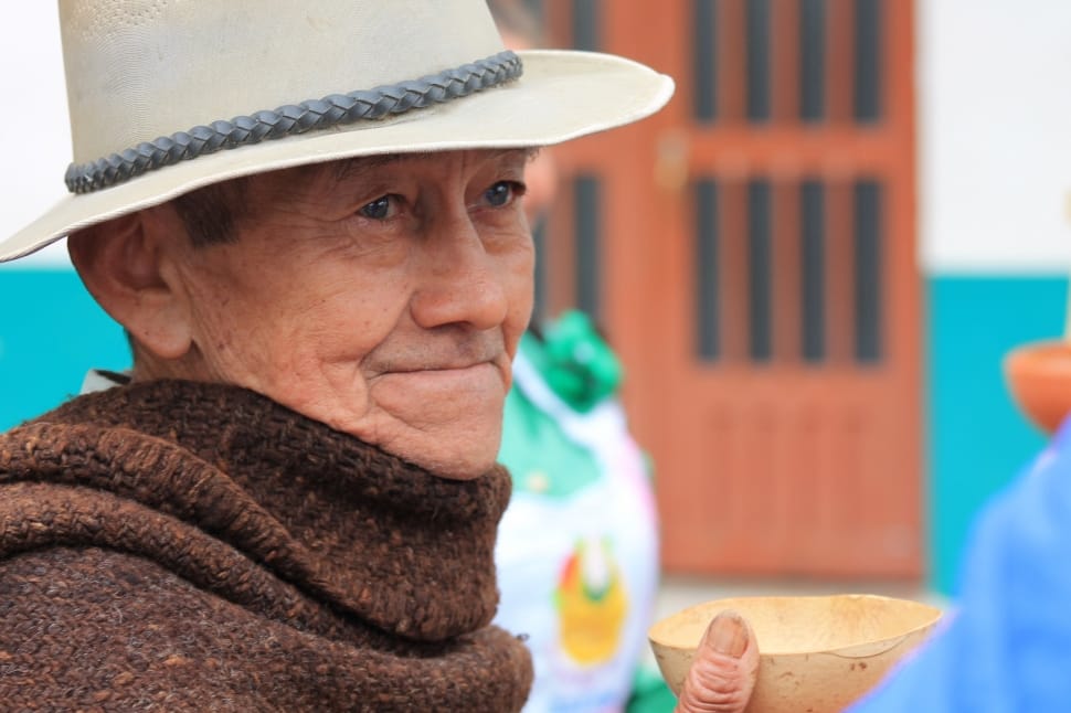 selective focus photography of man wearing hat and shawl preview
