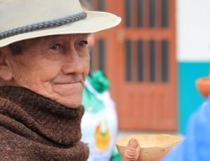 selective focus photography of man wearing hat and shawl thumbnail