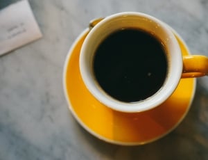 photography of yellow ceramic teacup with black coffee thumbnail