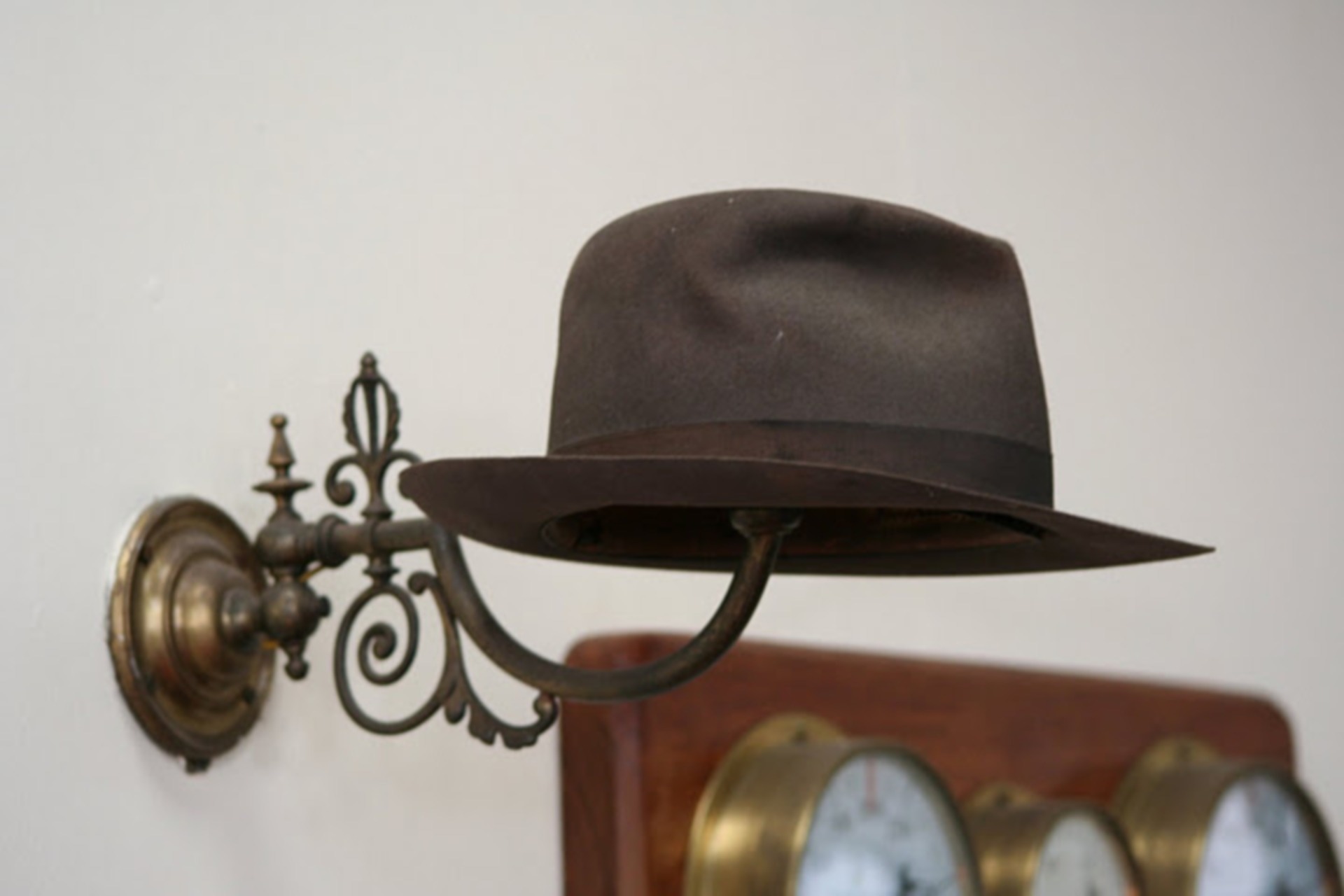 black hat and gray metal sconce hat holder