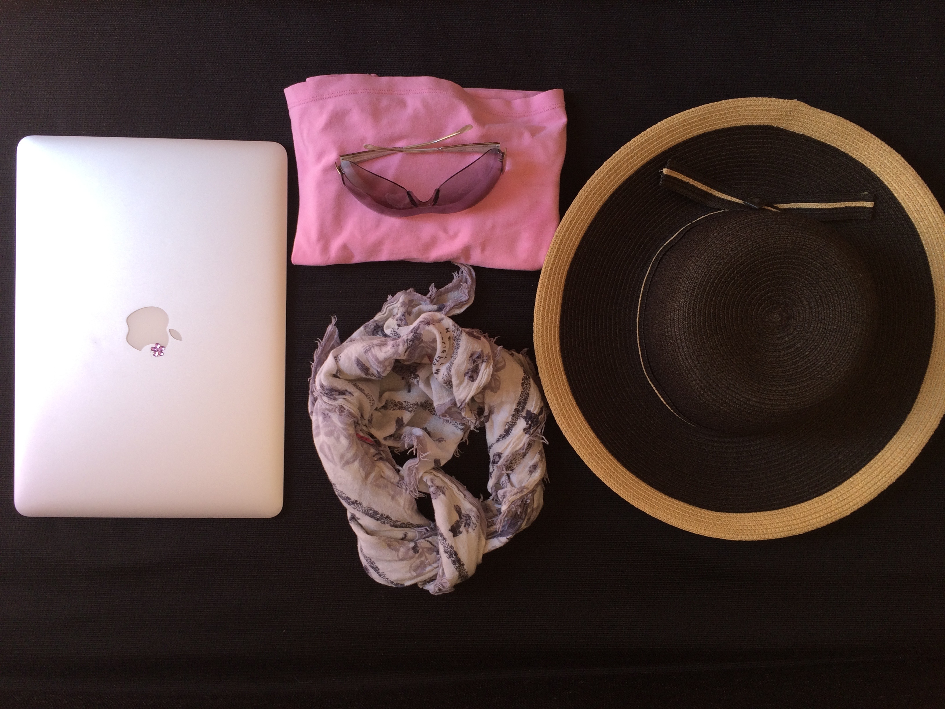silver macbook and black and brown sun hat and floral infinity scarf