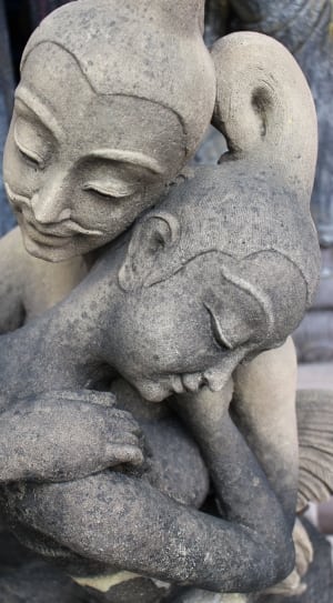 2 women hugging concrete figurine thumbnail