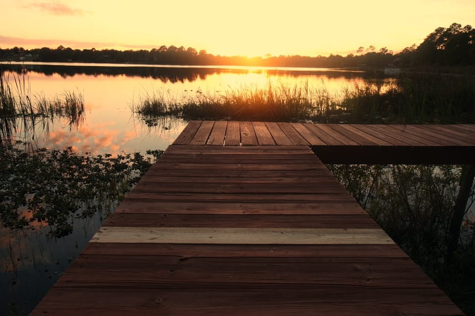 landscape picture of brown wooden bridge during sunset preview
