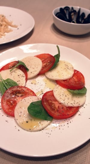 sliced cheese and tomatoes dish with pepper thumbnail
