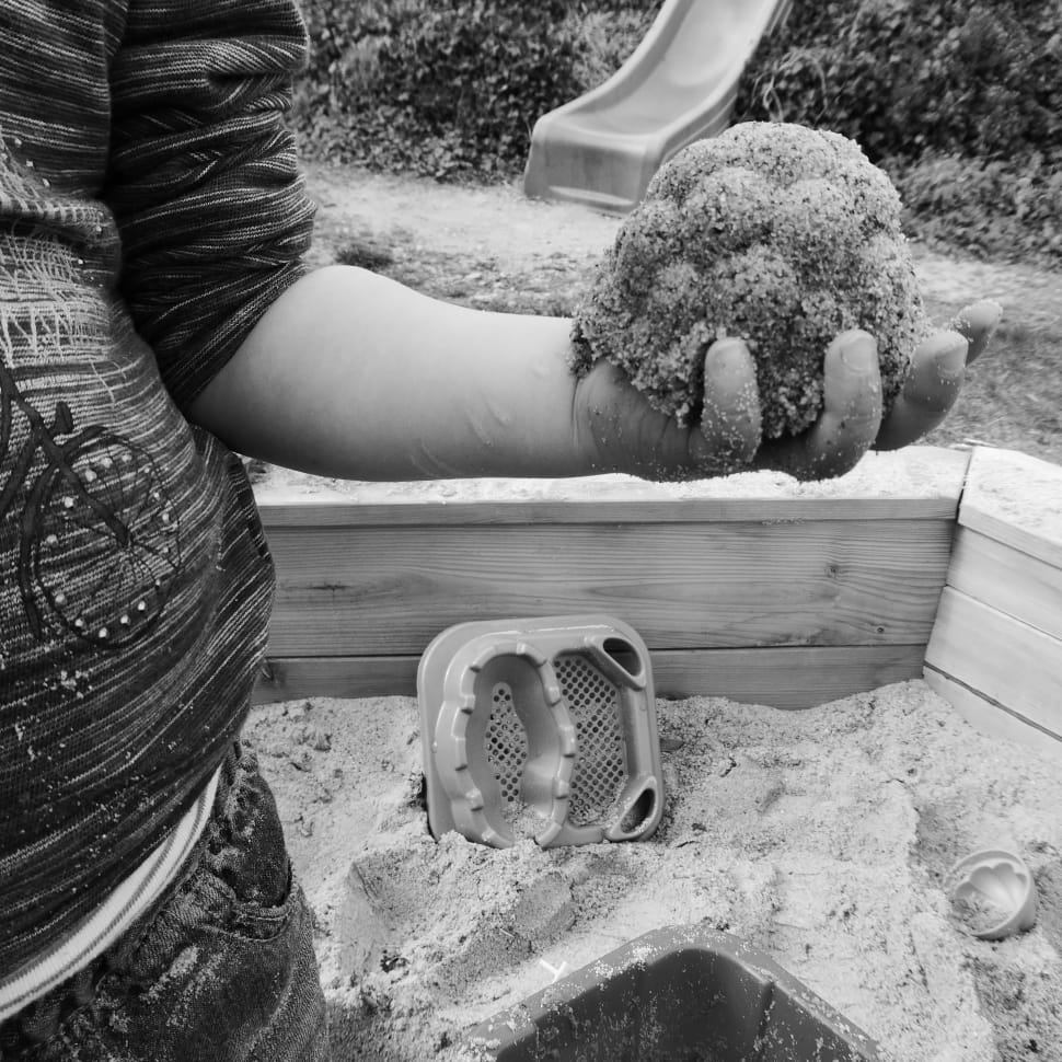 grayscale photo of person holding sand preview