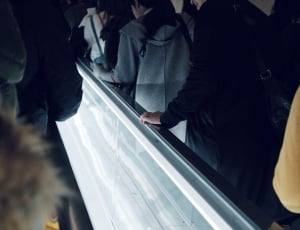 people climbing using escalator beside white led light thumbnail