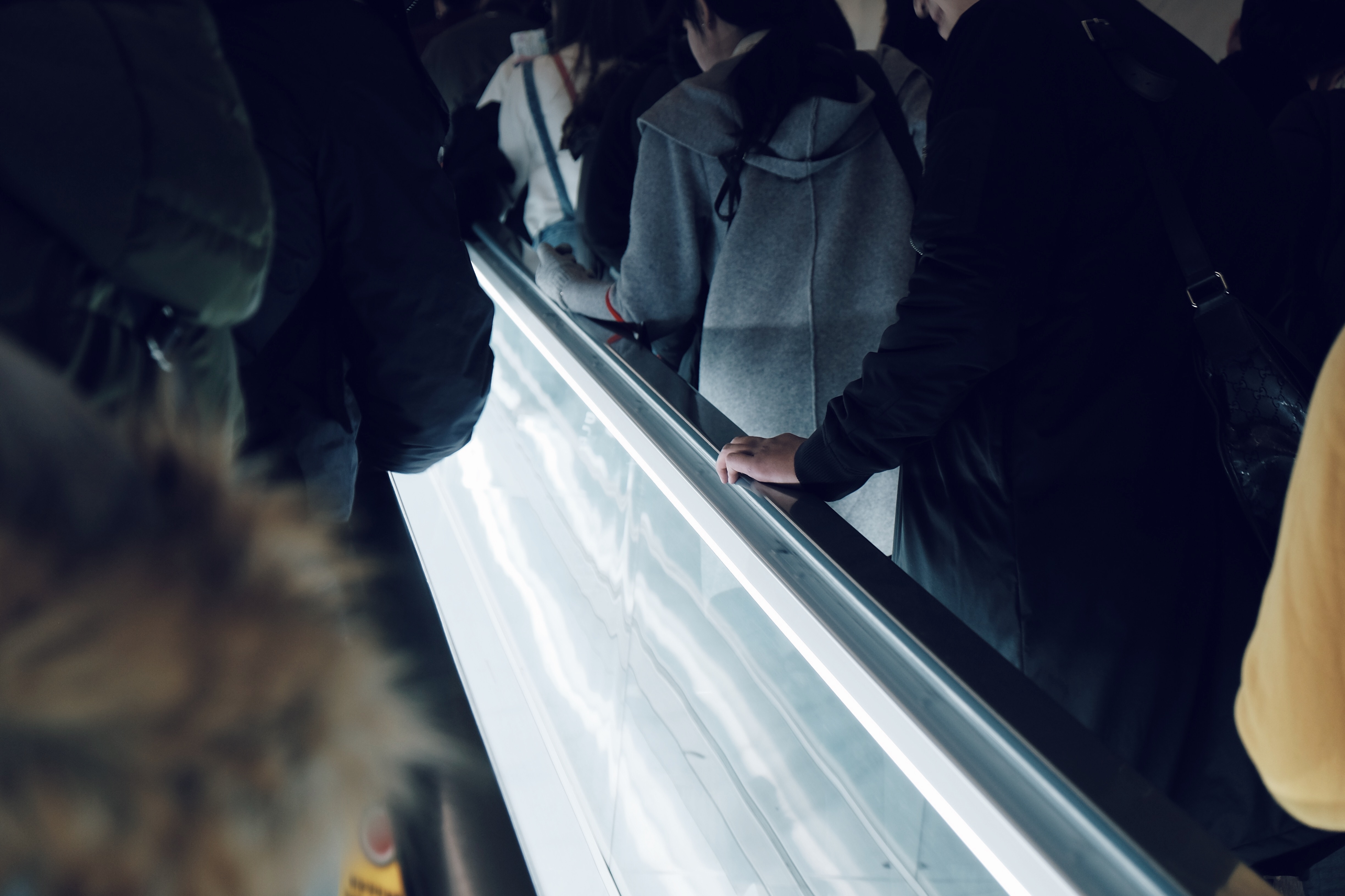 people climbing using escalator beside white led light