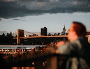 brown haired man watching a view of a city thumbnail