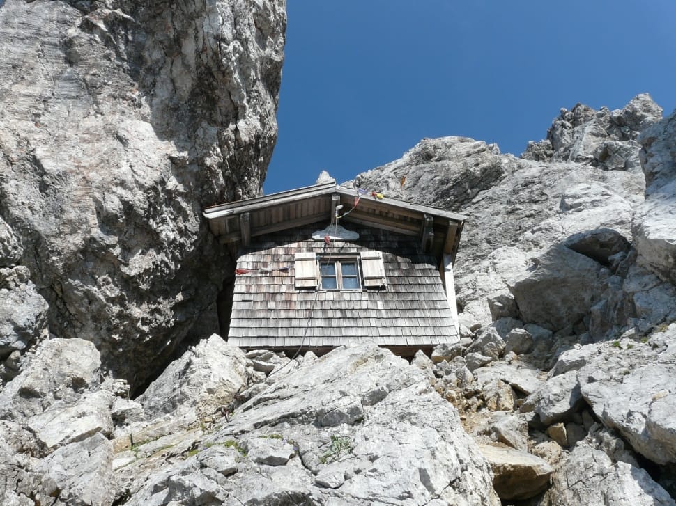 grey wooden house surrounded by concrete rocks preview