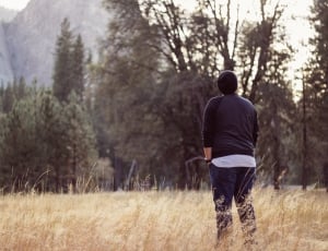 man in black long sleeved shirt and black pants standing in grass-field thumbnail