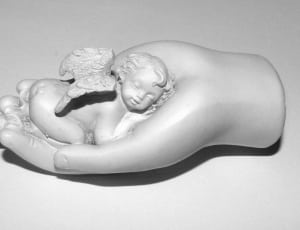cherub sleeping on hand ceramic figurine thumbnail