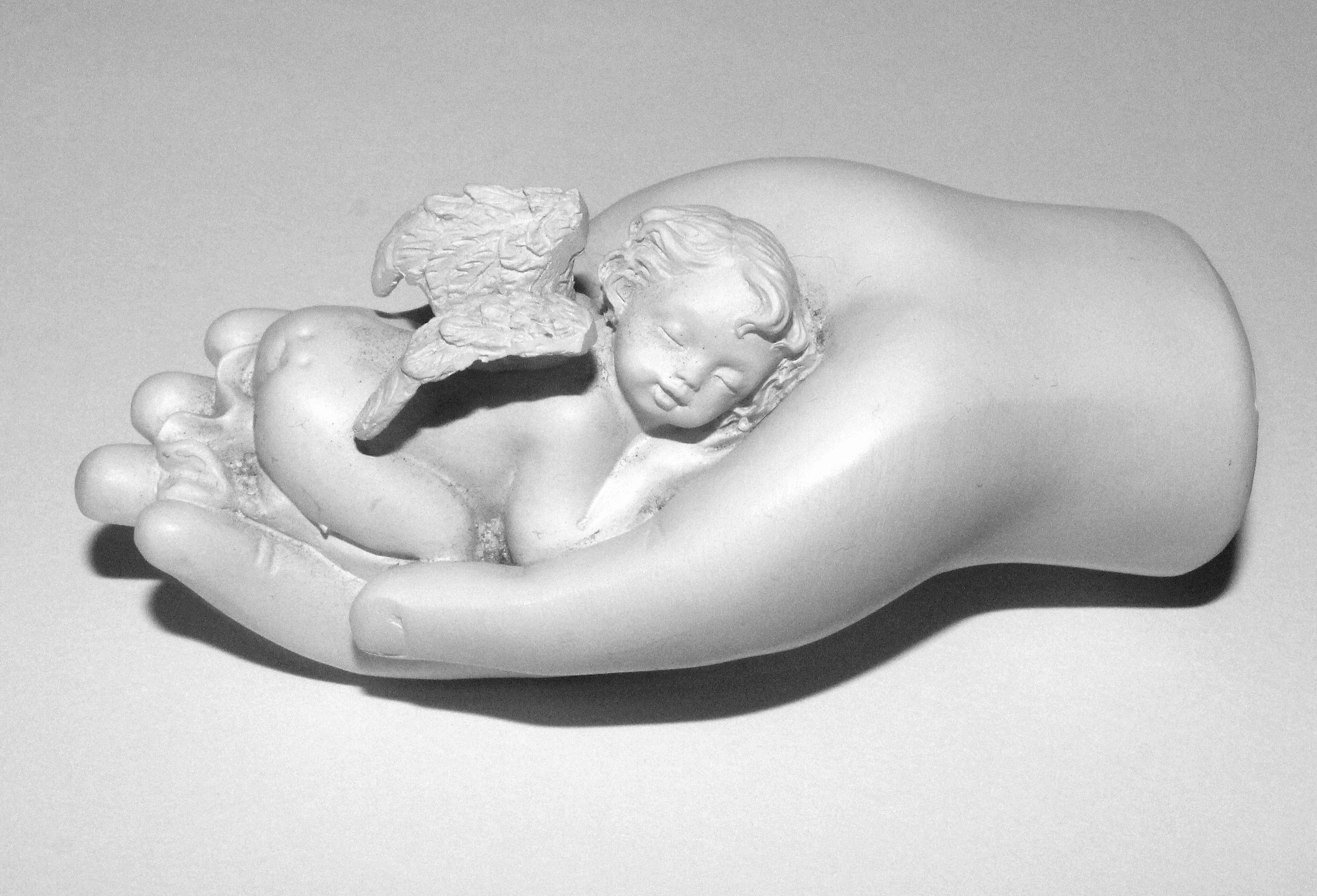 cherub sleeping on hand ceramic figurine
